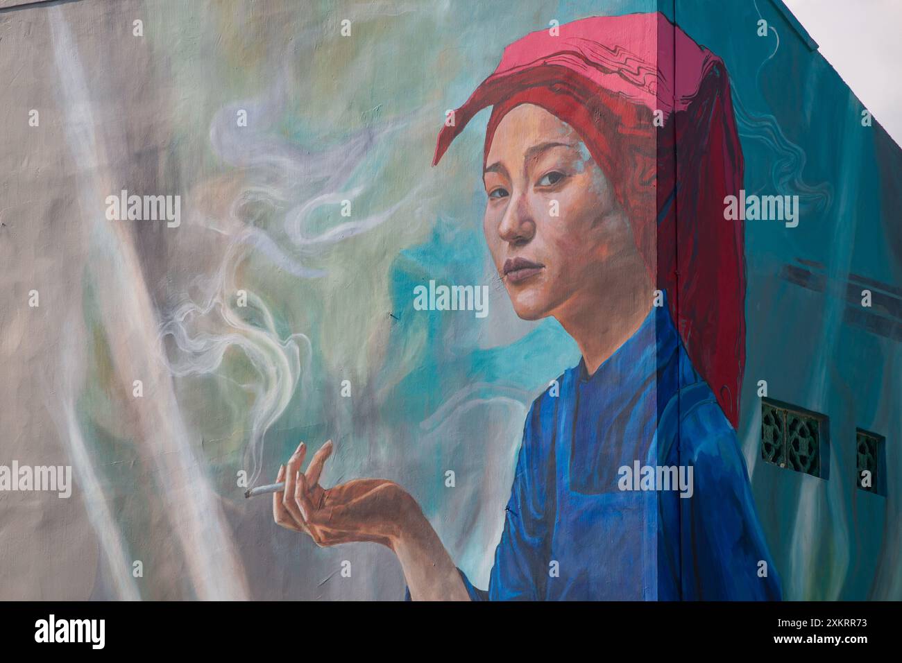 Vista ravvicinata di una donna Samsui dipinta che tiene una sigaretta con fumo sul murale. Chinatown, Singapore. Foto Stock