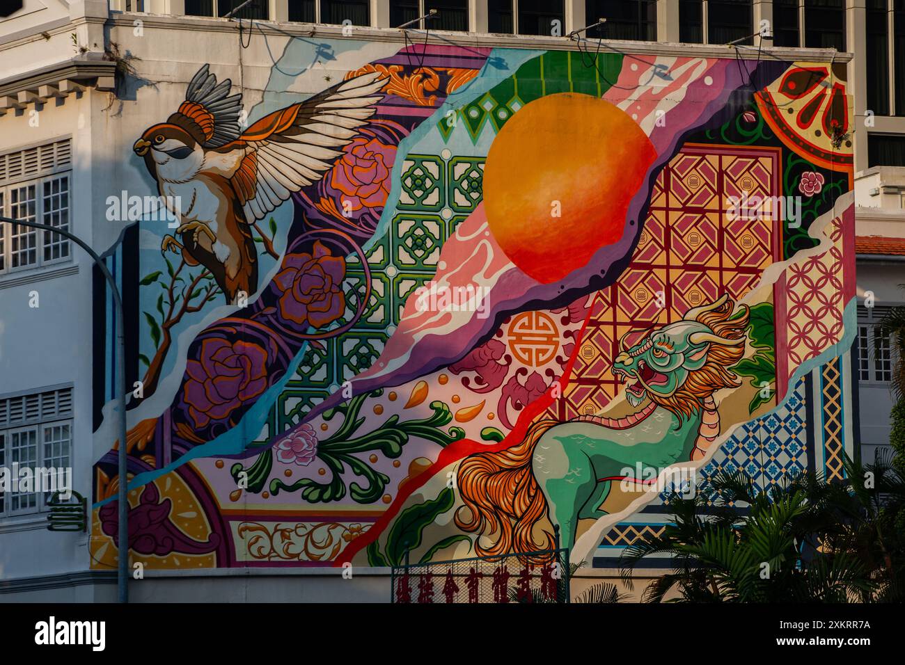 Murale colorato durante il periodo del tramonto che illumina la parete con luce dorata. Singapore. Foto Stock