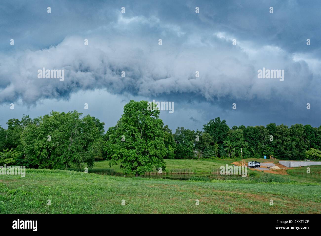 Una grande nube di temporali si muove rapidamente raccogliendo energia con venti che minacciano il cielo in un pomeriggio estivo Foto Stock