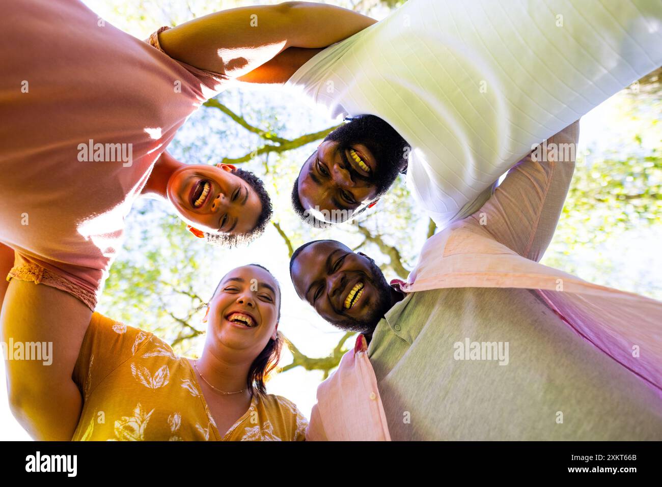 Amici in cerchio all'aperto, sorridono e si divertono insieme Foto Stock