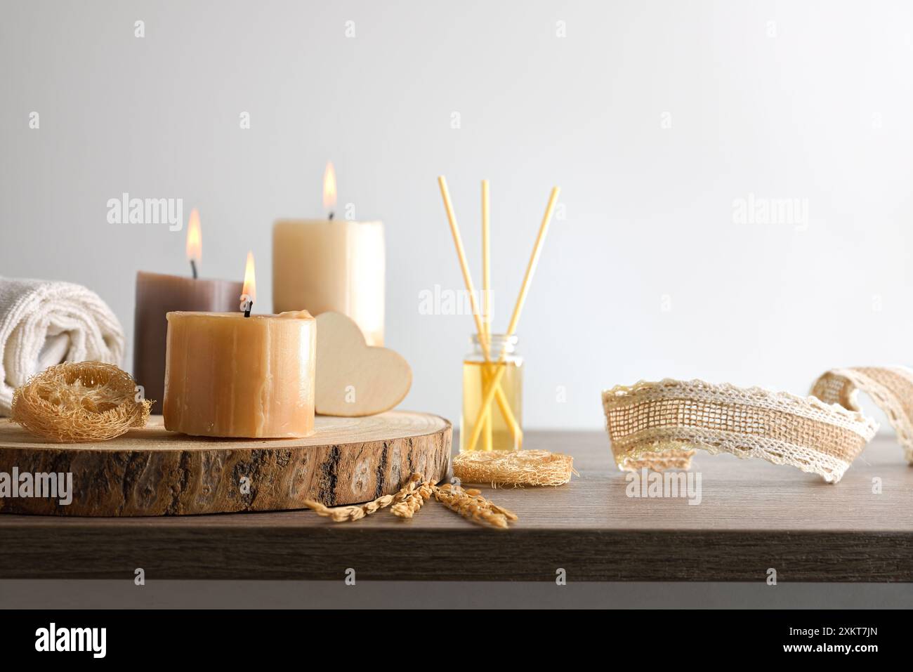 Benessere del corpo e aromaterapia con prodotti su un tavolo con candele ed elementi decorativi e sfondo isolato. Foto Stock