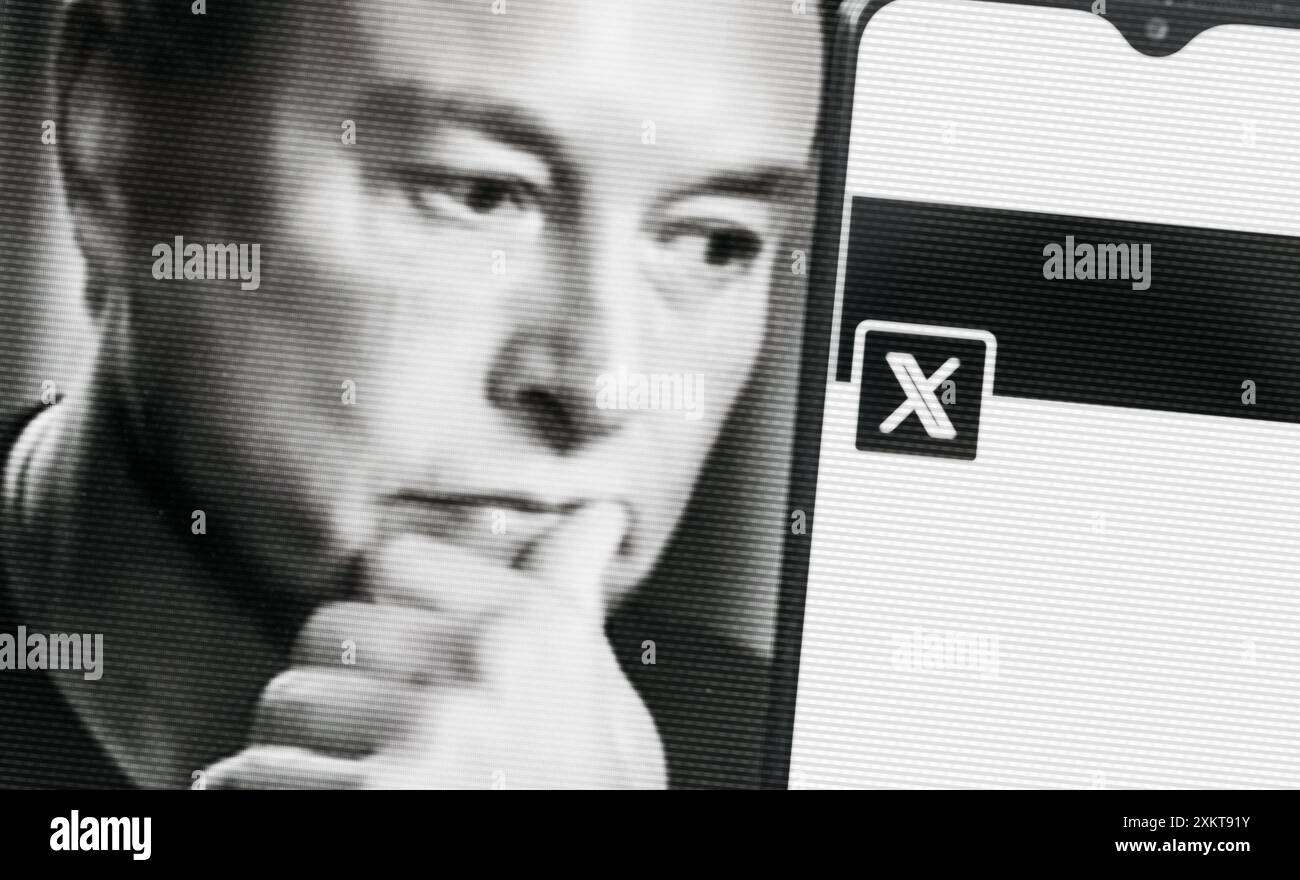 Elon Musk guarda uno smartphone con il nuovo logo Twitter. Copia spazio sullo smartphone. Foto Stock