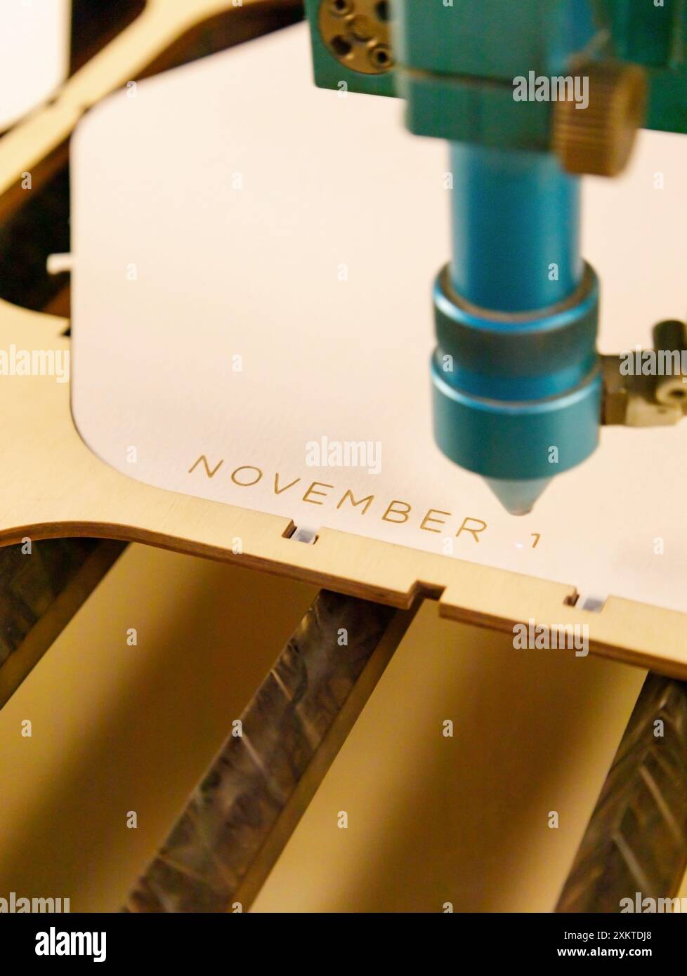 Taglio laser compensato e incisione legno testo iscrizione novembre specializzata macchina taglio albero su segheria. primo piano, verticale, all'interno Foto Stock