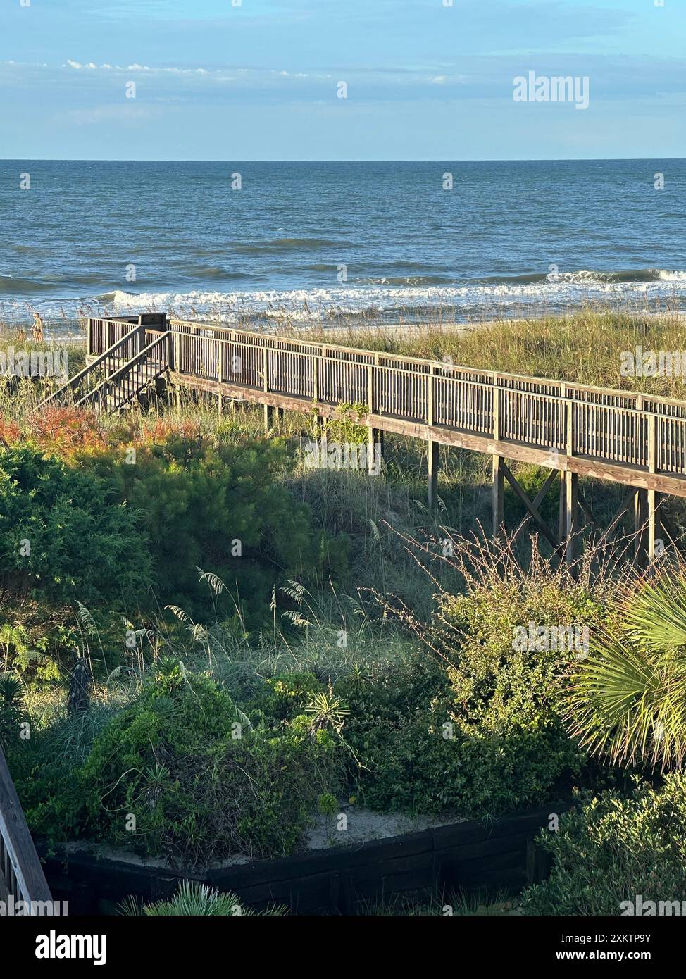 Una passerella di legno, accanto alle dune, conduce all'ampio oceano in una vacanza estiva, a North Myrtle Beach, South Carolina. Foto Stock