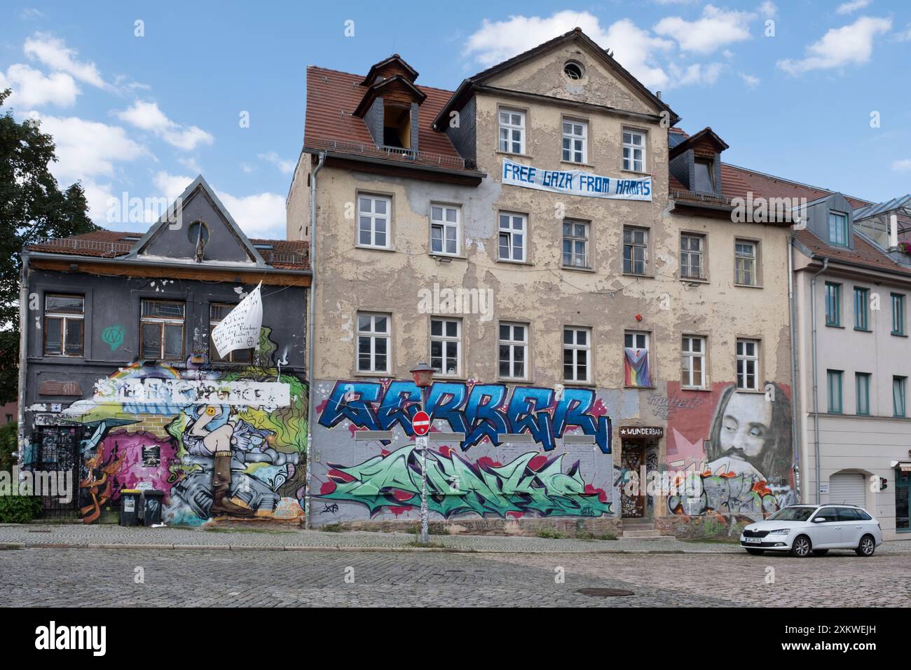 Edifici condannati nel quartiere storico, pieni di graffiti. Scena alternativa. Banner con testo "Free Gaza from Hamas" Foto Stock