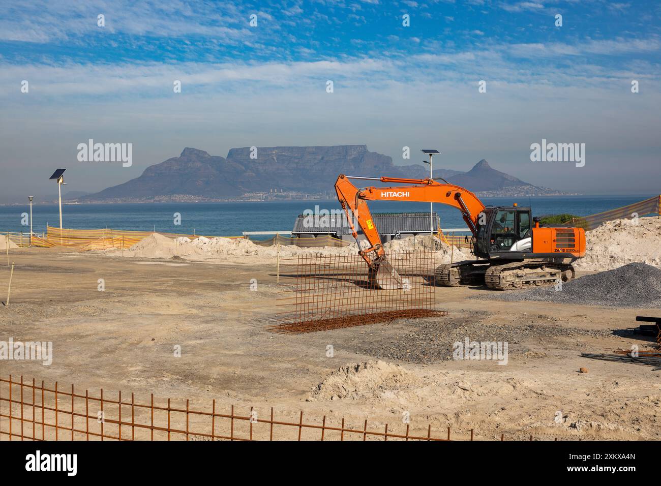 Cantiere per la spiaggia appiattito e pronto per la costruzione a Blouberg Strand città del Capo. Escavatore Hitachi in loco. Foto Stock