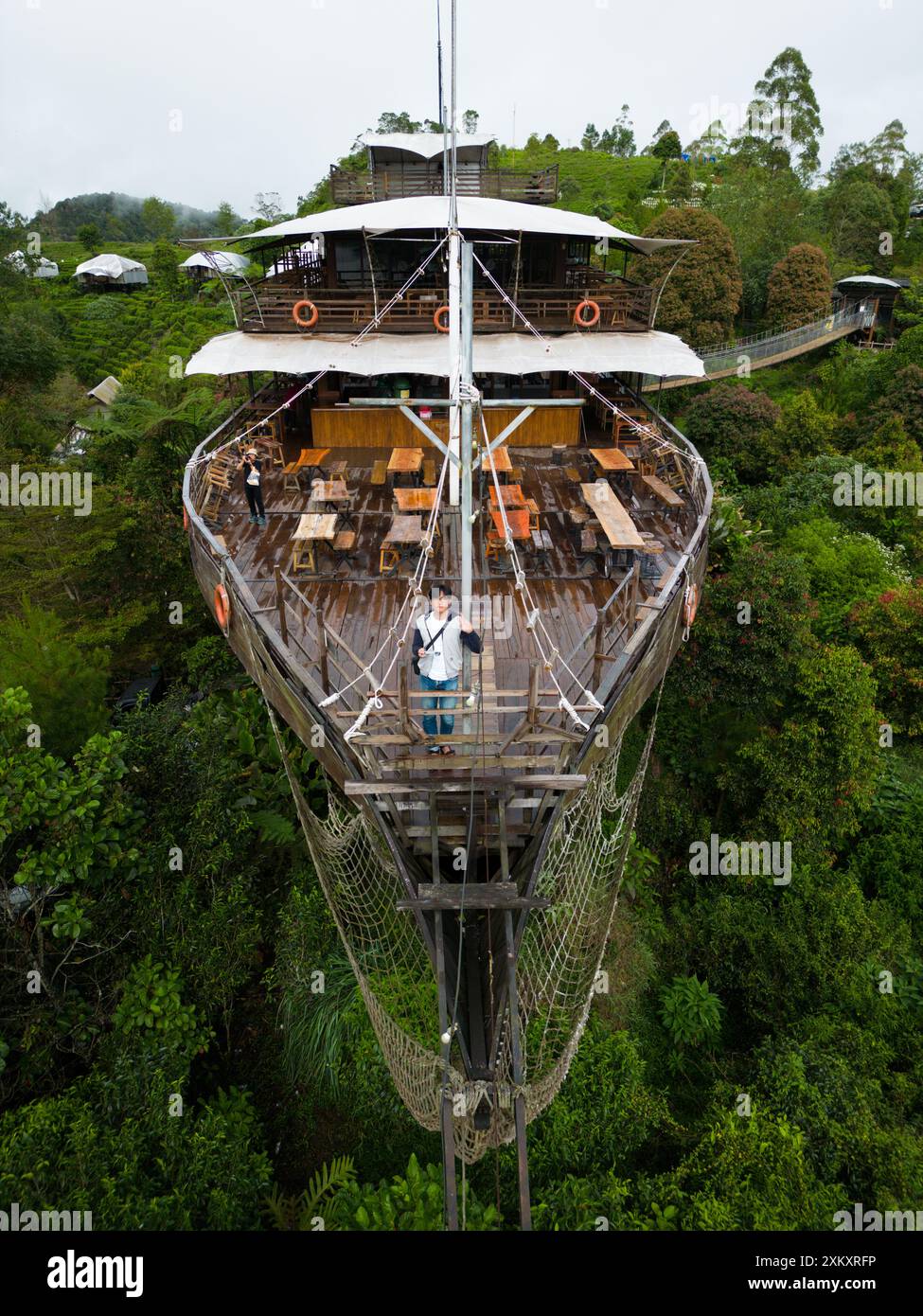 Il turista asiatico posa sul ponte del grande ristorante di navi in legno nella foresta di Lembang Foto Stock