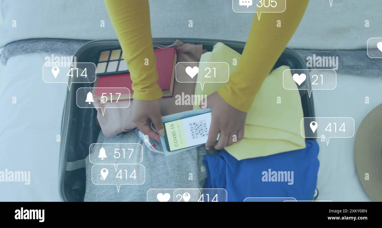 Immagine delle notifiche dei media su una donna birazziale con valigia per smartphone Foto Stock