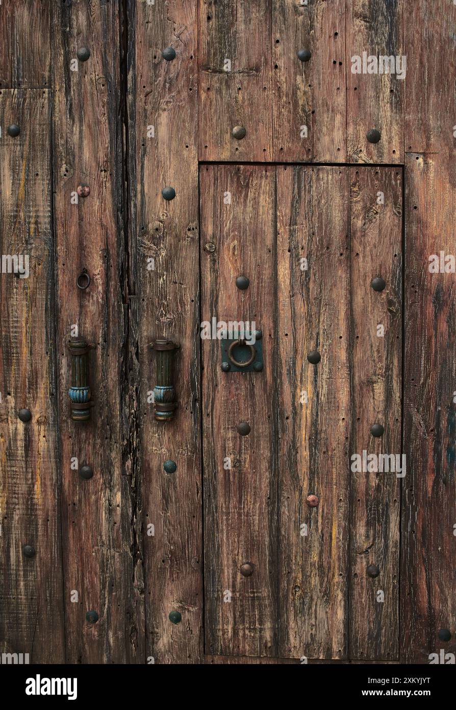 grande porta in legno vecchio stile medievale con dettagli e piatti in bronzo, non c'è nessuno Foto Stock