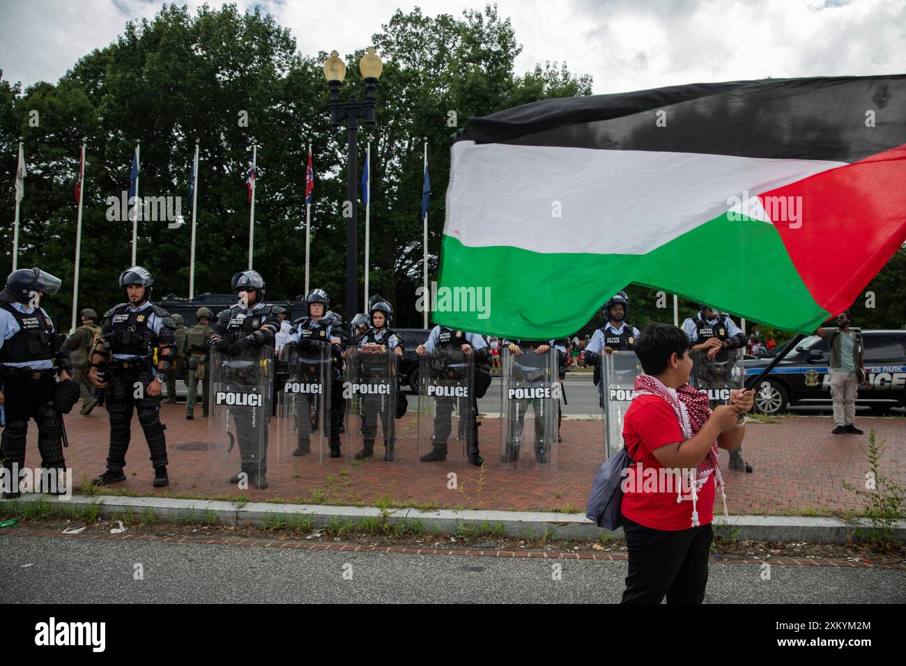 Washington DC, USA, USA, 24 luglio 2024. Un filo-palestinese sta sventolando una bandiera durante una protesta alla Union Station, Washington DC, USA, il 24 luglio 2024. Migliaia di persone sono riunite per dimostrazioni con una serie di richieste, tra cui il rilascio di ostaggi, il cessate il fuoco di Gaza e l'arresto del primo ministro israeliano Benjamin Netanyahu. Nel giorno in cui Netanyahu si rivolse al Congresso degli Stati Uniti a Washington, mentre cercava di rafforzare il sostegno degli Stati Uniti alla guerra del suo paese a Gaza. (Foto di Aashish Kiphayet/ Alamy Live News) Foto Stock