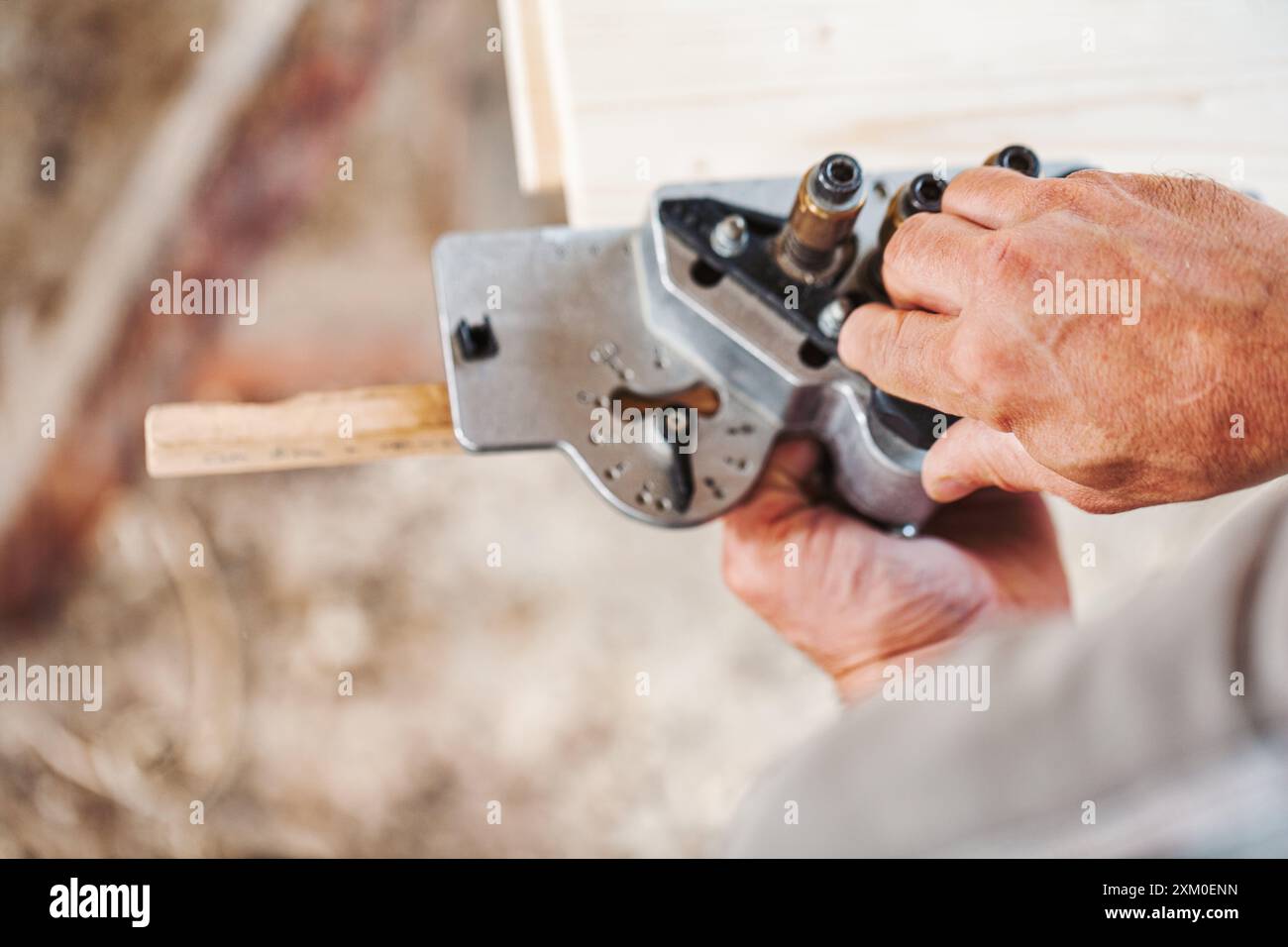 Falegname esperto che utilizza una dima per tasselli per falegnameria in legno precisa in un'officina, mostrando maestria e competenza nella produzione di mobili Foto Stock