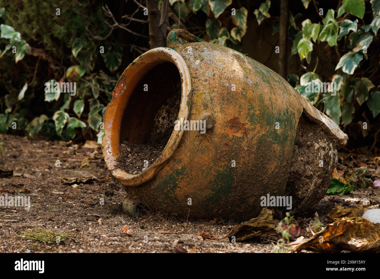 Vaso di ceramica rotto con terreno all'interno che decora il giardino di una casa, Alcoy, Spagna Foto Stock