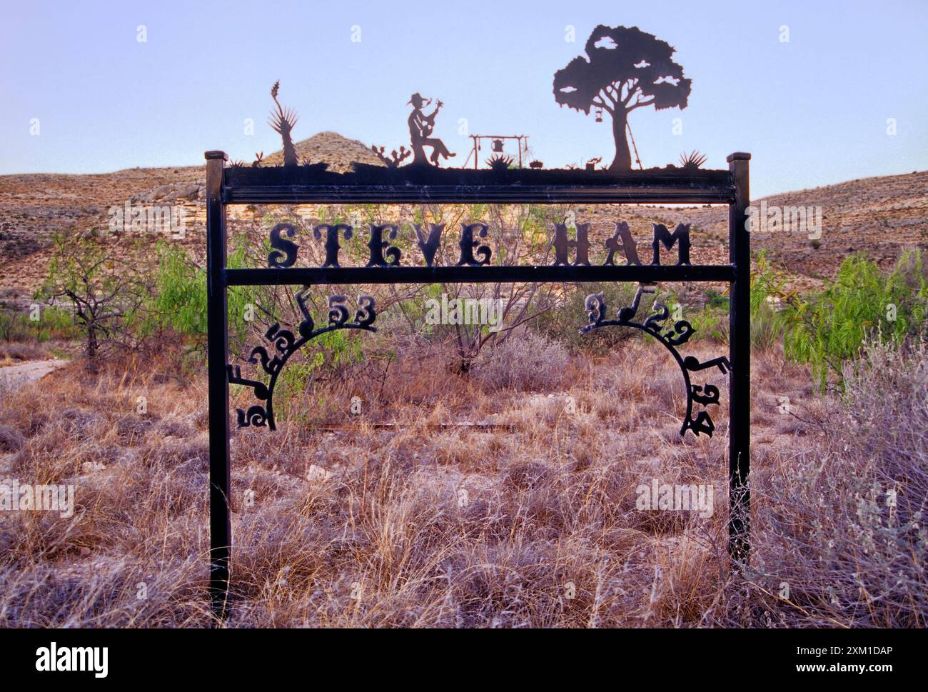 Insegna in ferro battuto per commemorare una persona all'ingresso del ranch al crepuscolo vicino a Pandale, Pecos River Valley, Stockton Plateau nella Val Verde County, Texas, USA Foto Stock