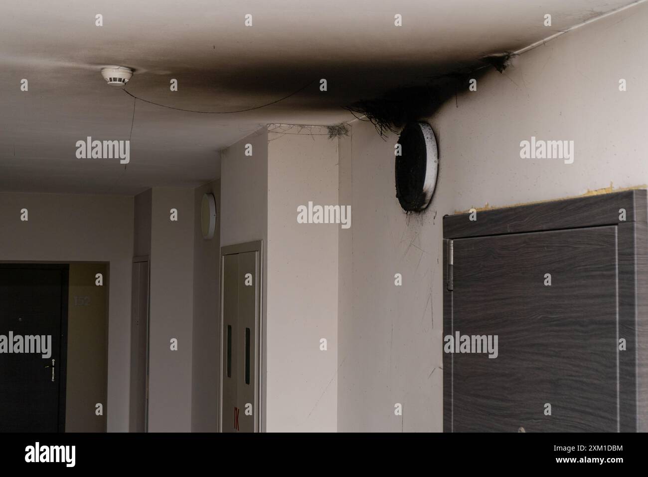 Lampada LED bruciata. Una lampada a paralume sulla parete dopo un incendio. Combustione spontanea e incendio in un edificio residenziale. Sensore di allarme antincendio interno. Porta Foto Stock