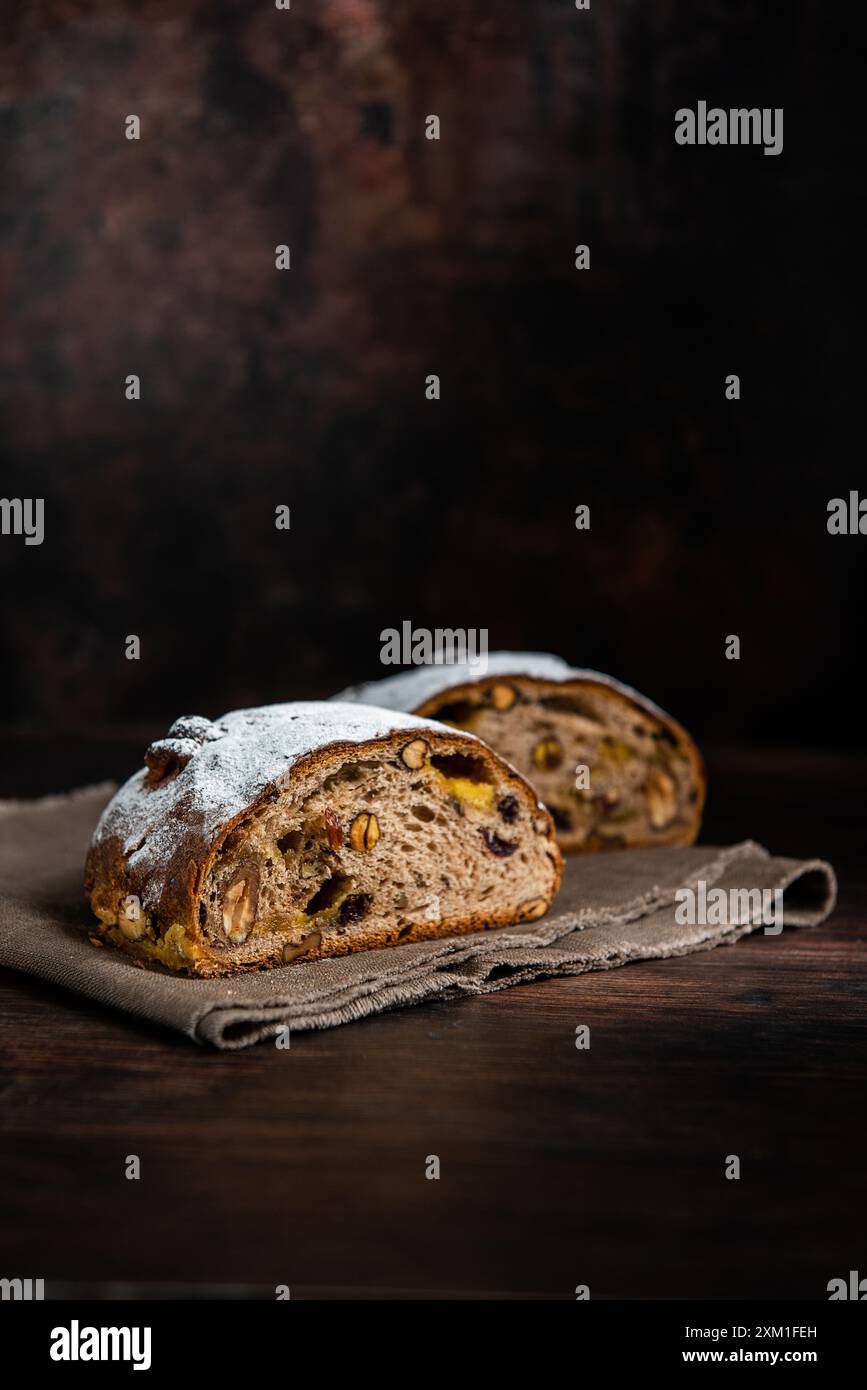 Pane a pasta madre fresca con frutta e noci su un tavolo di legno. Foto Stock