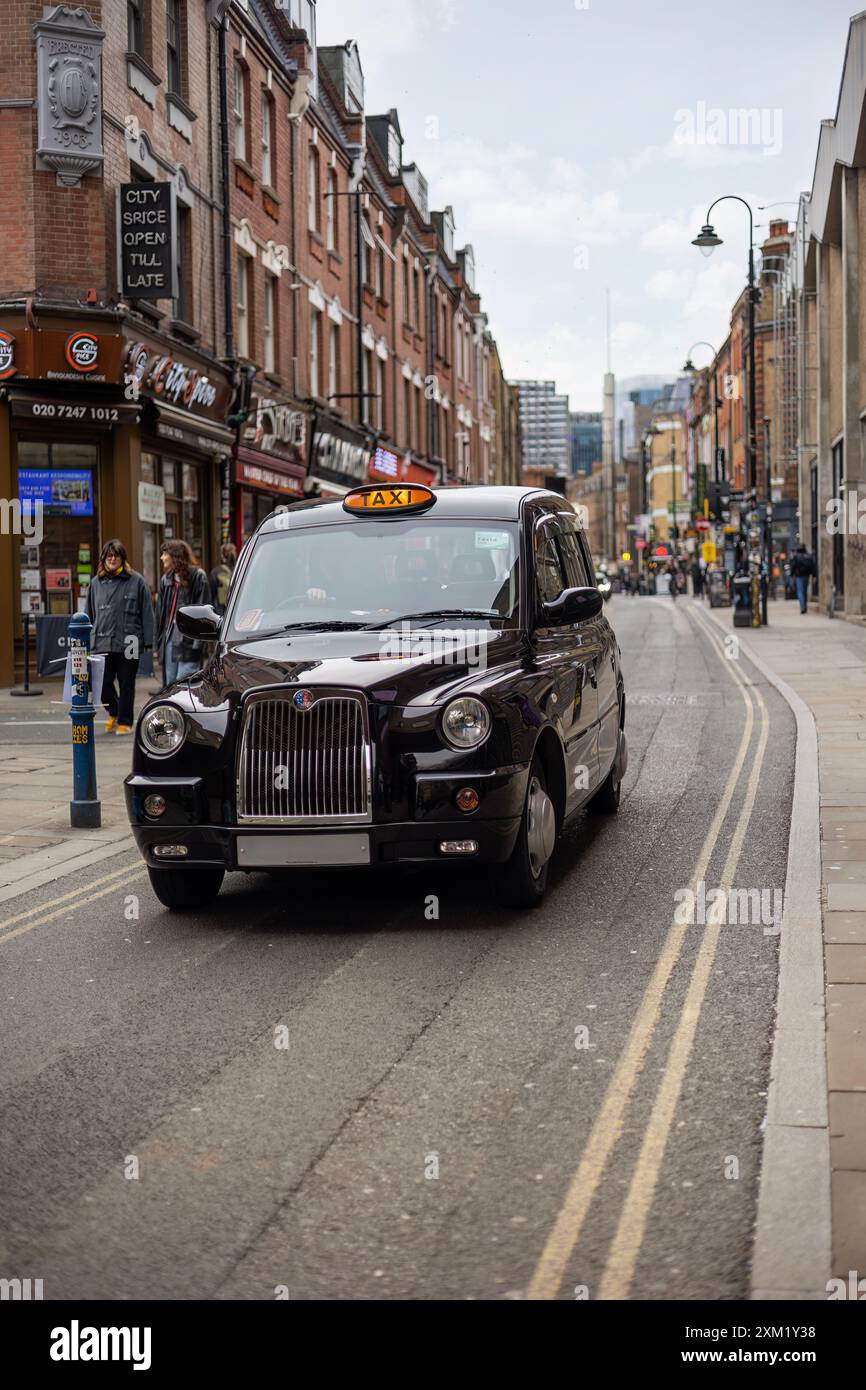 Taxi nero lucido in una strada stretta. Foto Stock