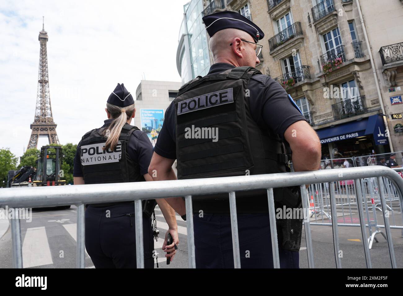 Parigi, Francia. 25 luglio 2024. Olimpiadi, Olimpiadi estive, Parigi 2024, preparativi, gli agenti di polizia si trovano in una barriera di fronte alla Torre Eiffel. Crediti: Marcus Brandt/dpa/Alamy Live News Foto Stock