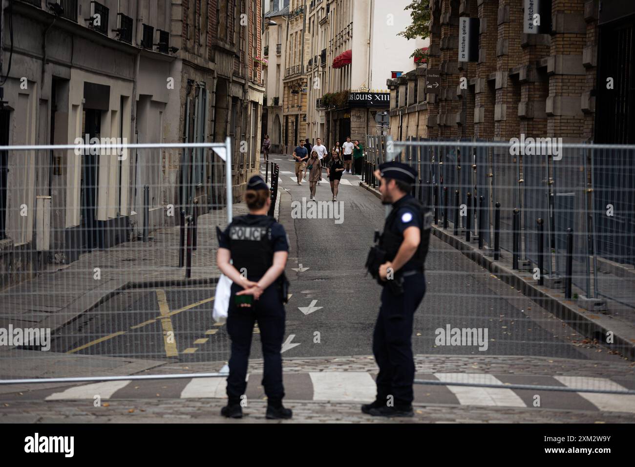 Parigi, Francia. 23 luglio 2024. Gli agenti di polizia sorvegliano un punto d'ingresso al perimetro di sicurezza durante i preparativi per le Olimpiadi di Parigi. Pochi giorni prima dell'inaugurazione senza precedenti dei Giochi Olimpici di Parigi, che si svolgeranno lungo i 6 chilometri della Senna, la città della luce è in fase di metamorfosi. Le ringhiere sono state erette intorno al perimetro molto ristretto dell'area dove si svolgerà la cerimonia di apertura, in modo da poter vedere strade completamente vuote, così come le terrazze di caffè e ristoranti. (Foto di Telmo Pinto/SOPA Images/Sipa USA) credito: SIPA USA/Alamy Live News Foto Stock