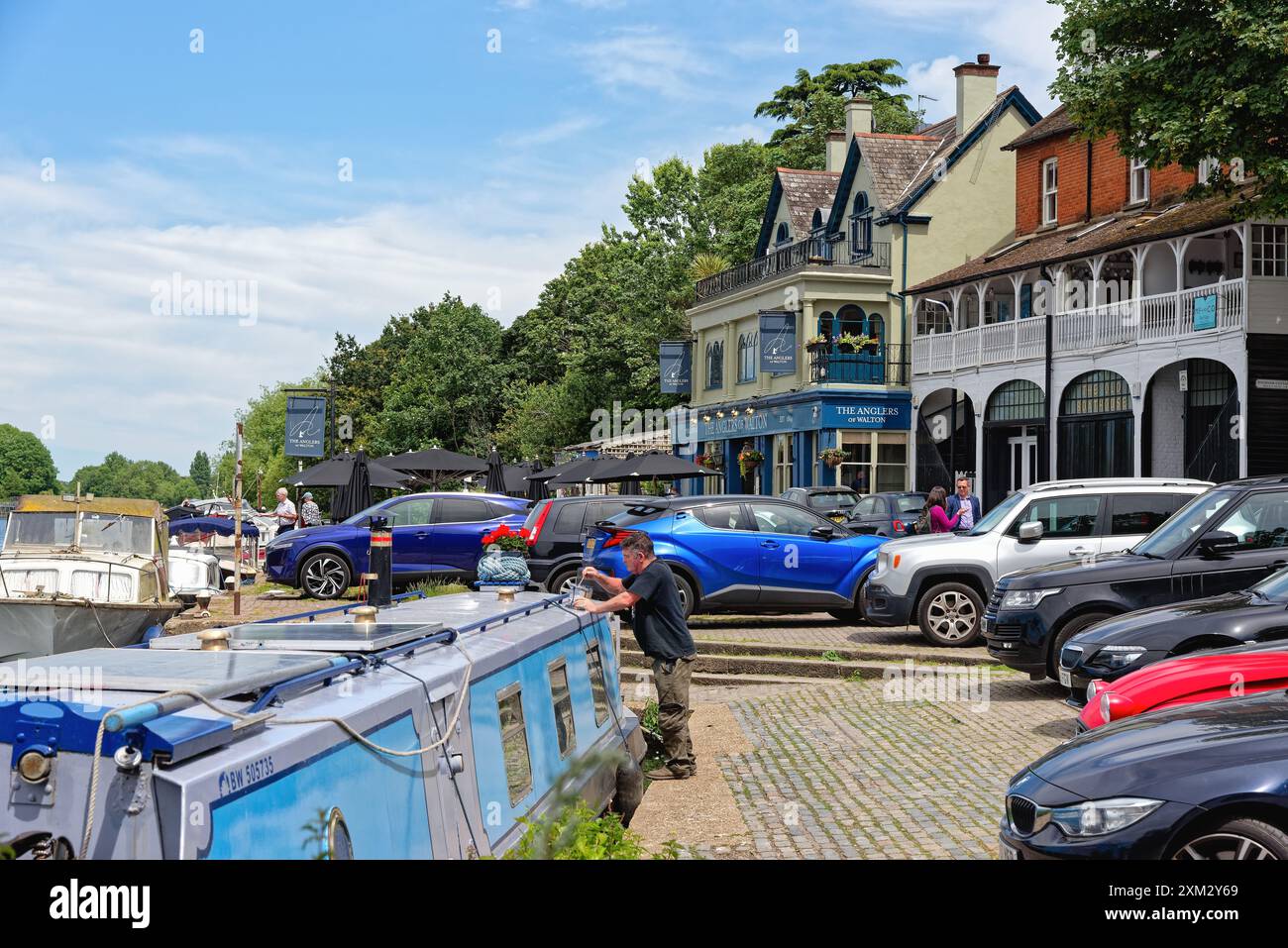 Un'affollata scena lungo il fiume presso la casa pubblica Anglers a Walton sul Tamigi in una soleggiata giornata estiva Surrey Inghilterra Regno Unito Foto Stock