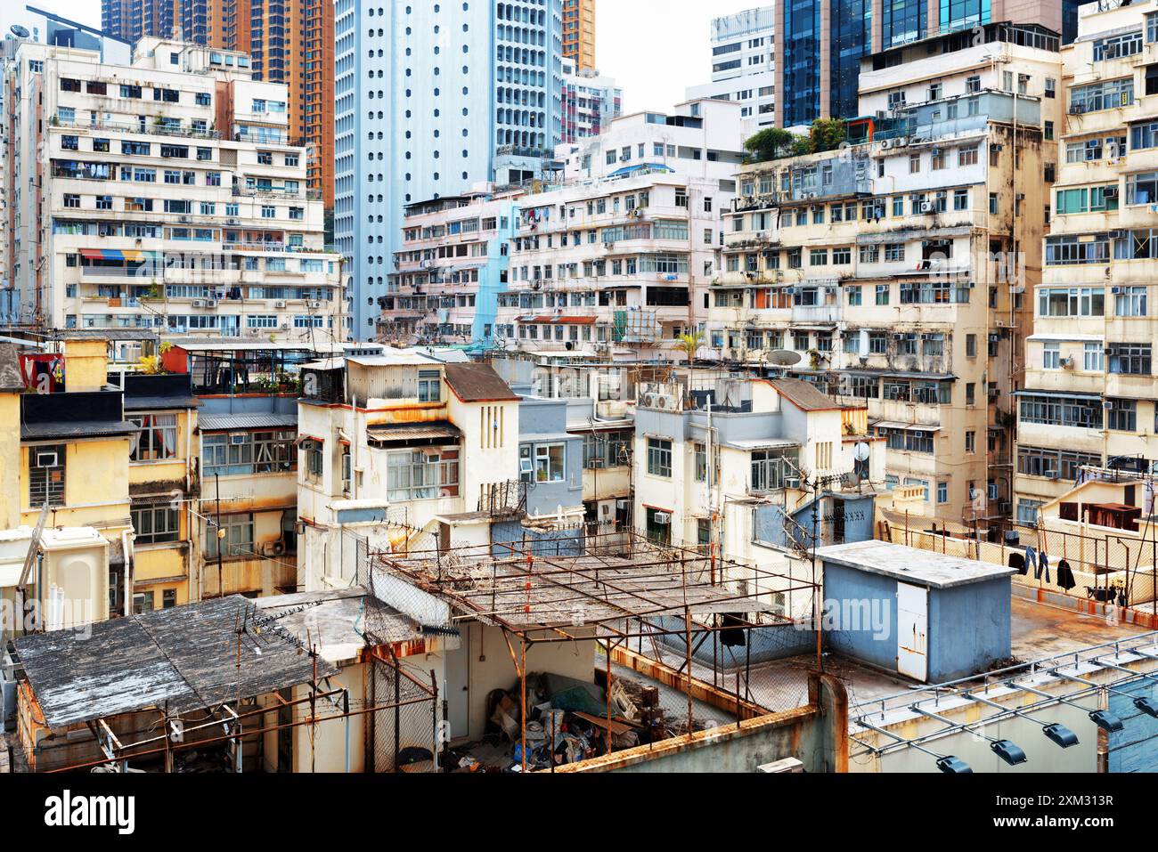 Vecchie case circondavano moderni grattacieli a Hong Kong Foto Stock