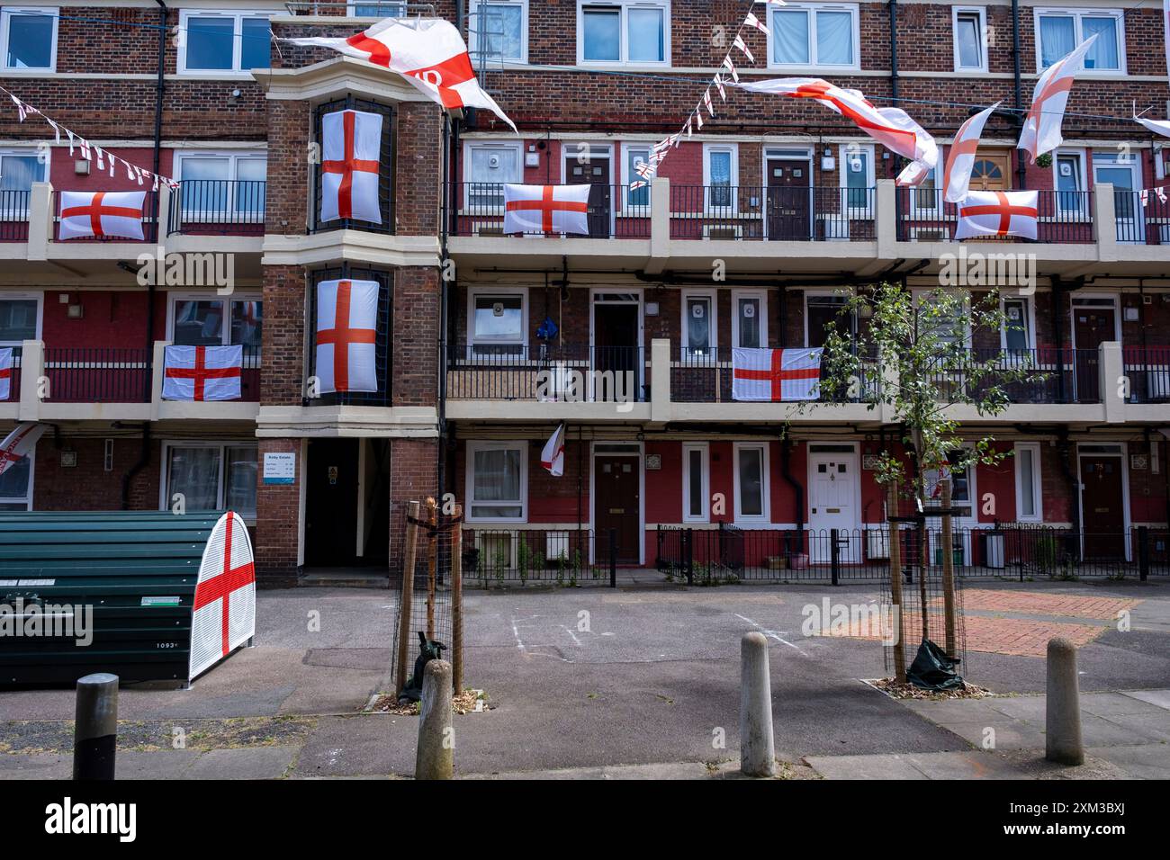 St Georges Cross bandiere a sostegno della squadra di calcio inglese Euro 2024 in alto sopra la tenuta di Kirby a Bermondsey il 4 luglio 2024 a Londra, Regno Unito. Foto Stock