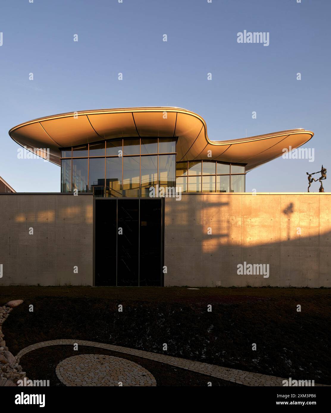 Facciata all'ultimo piano con tetto galleggiante in calda luce pomeridiana. Stiftung Froehlich - Collezione Froehlich, Leinfelden-Echterdingen, Germania. Architetto: G Foto Stock
