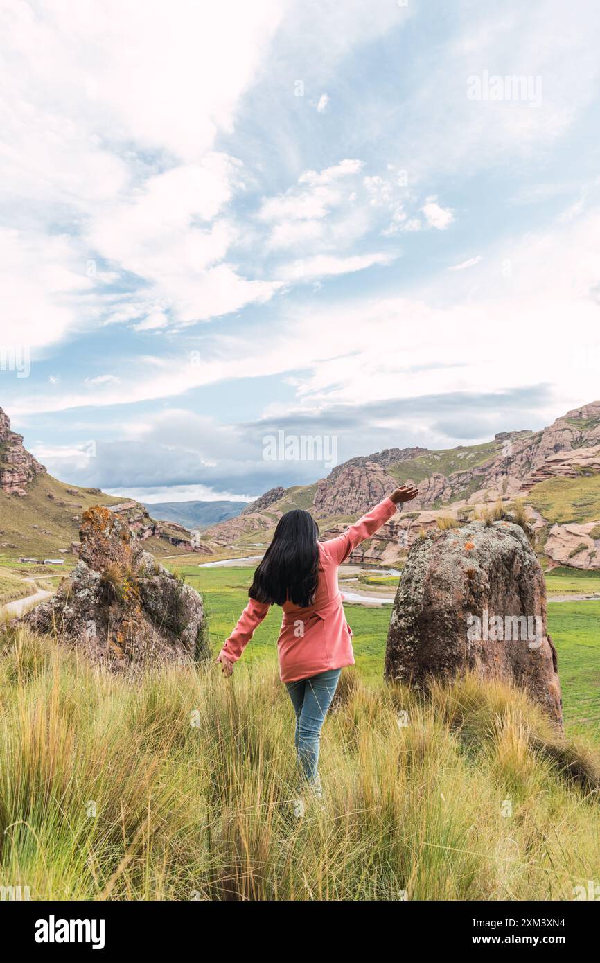 bellissimo giovane avventuriero nel canyon tinajani nelle ande peruviane circondato da nuvole e un cielo blu Foto Stock