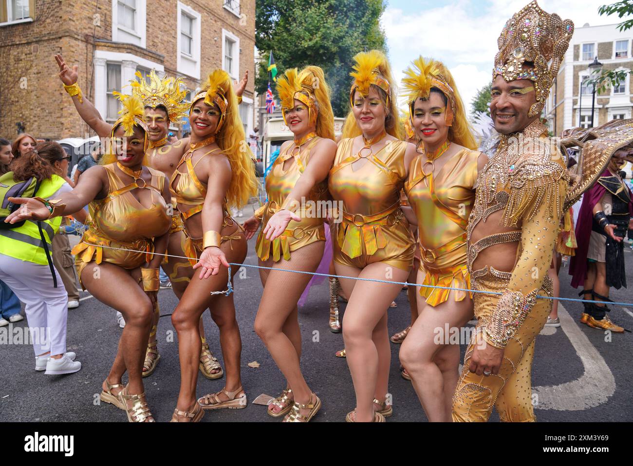 Notting Hill Carnival a Londra, Regno Unito: Un gruppo di artisti di carnevale in costumi dorati per strada Foto Stock