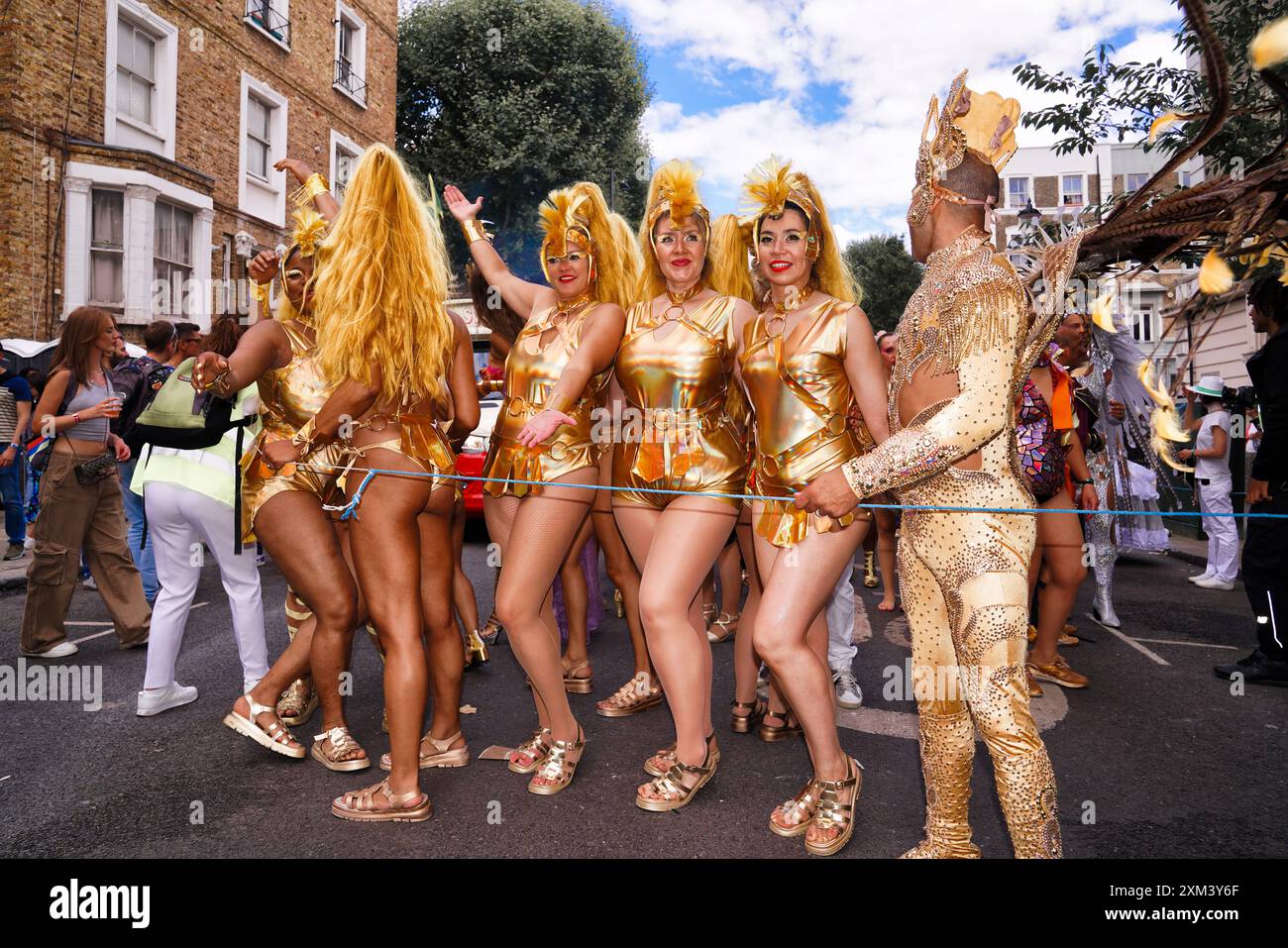 Notting Hill Carnival a Londra, Regno Unito: Un gruppo di artisti di carnevale in costumi dorati per strada Foto Stock