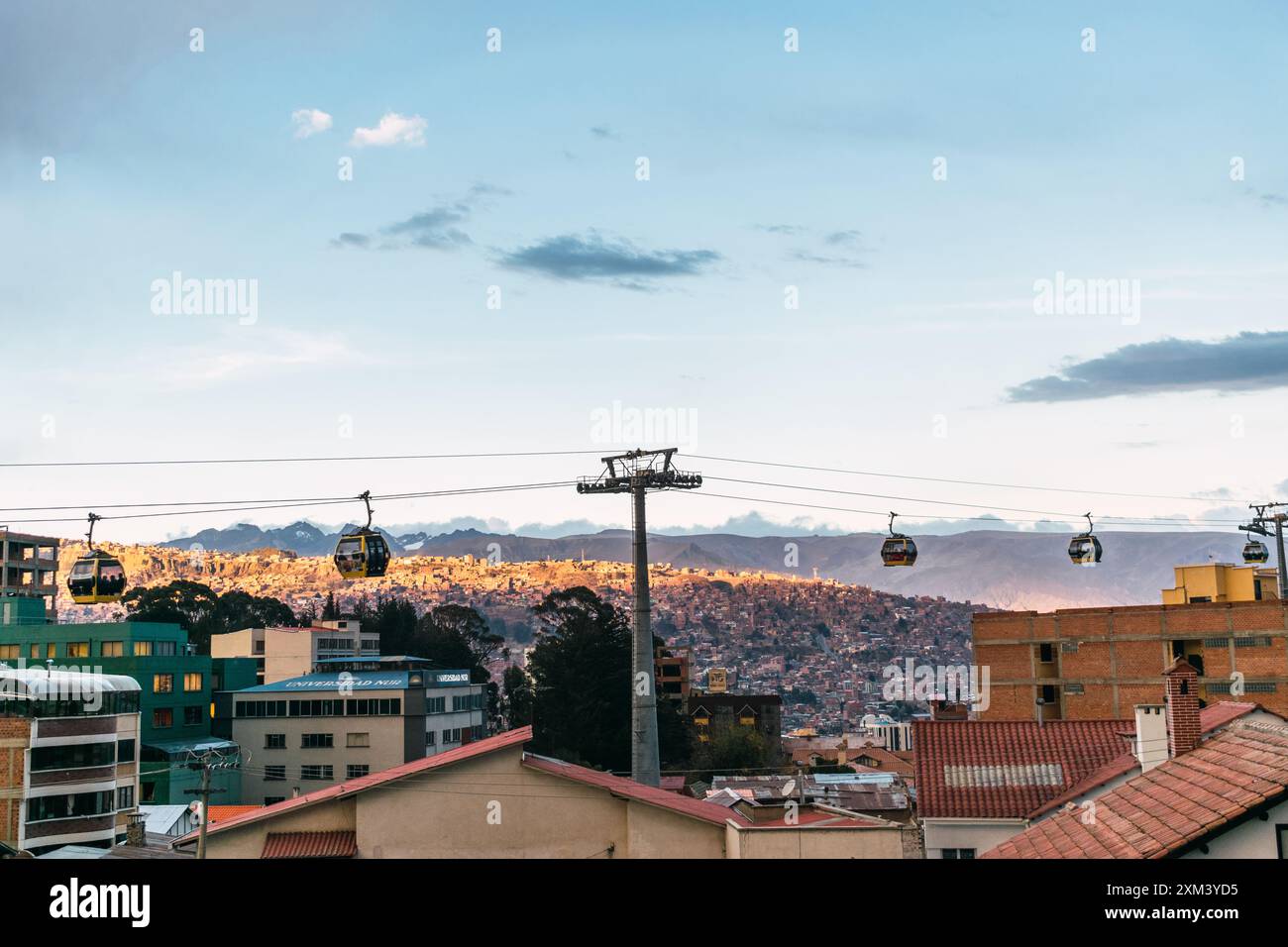 funivia gialla con una vista della città di bolivia e di el alto in un tramonto con cielo blu e nuvole con luce naturale Foto Stock