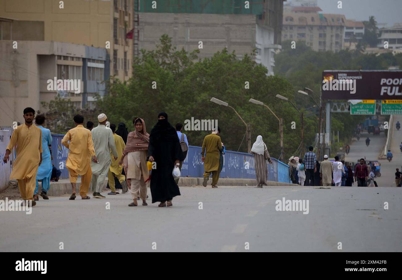 I pendolari hanno visto preoccupati e affrontare problemi a causa della strada chiusa durante le operazioni ricorrenti dopo un incidente stradale mortale, al Baloch Colony Bridge di Karachi giovedì 25 luglio 2024. Un'auto è stata schiacciata sotto una petroliera vicino al Baloch Colony Bridge a Karachi, causando un ingorgo stradale e sollevando preoccupazioni per un potenziale rischio di incendio. L'autista della petroliera è fuggito dalla scena dopo l'incidente. La petroliera ha iniziato a perdere benzina, causando una significativa interruzione del traffico. I soccorritori hanno richiesto macchinari pesanti per sollevare la cisterna e liberare l'auto. Foto Stock