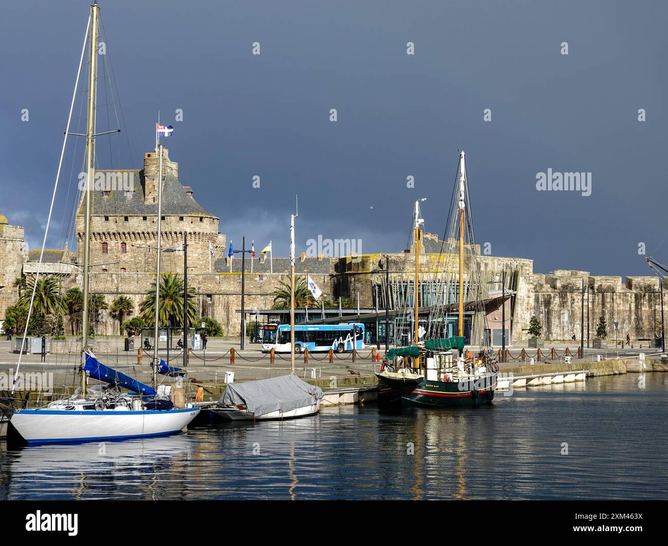 Guardando attraverso il porto di Saint-Malo, Bretagna, Francia verso la città fortificata, la città vecchia, sotto nuvole di tempesta buie. Foto Stock