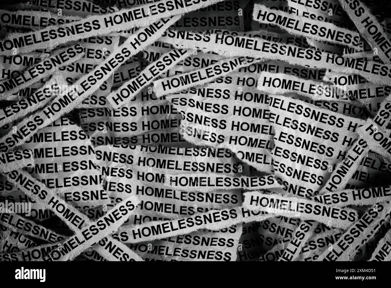 Strisce di giornali con le parole Homelessness scritte sopra. Bianco e nero. Primo piano. Foto Stock