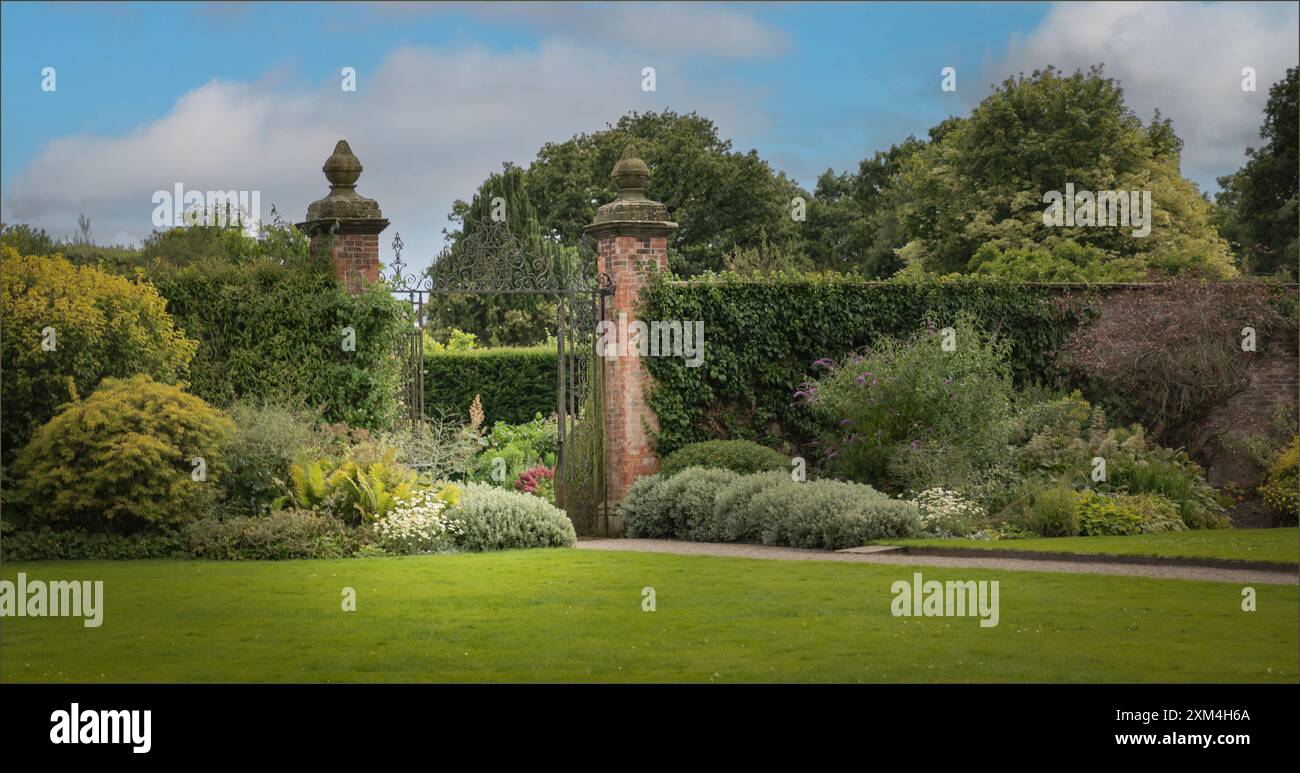 Arley, West Cheshire, Regno Unito - 17 luglio 2024 - porta d'ingresso in metallo ornato che conduce ad un giardino Foto Stock