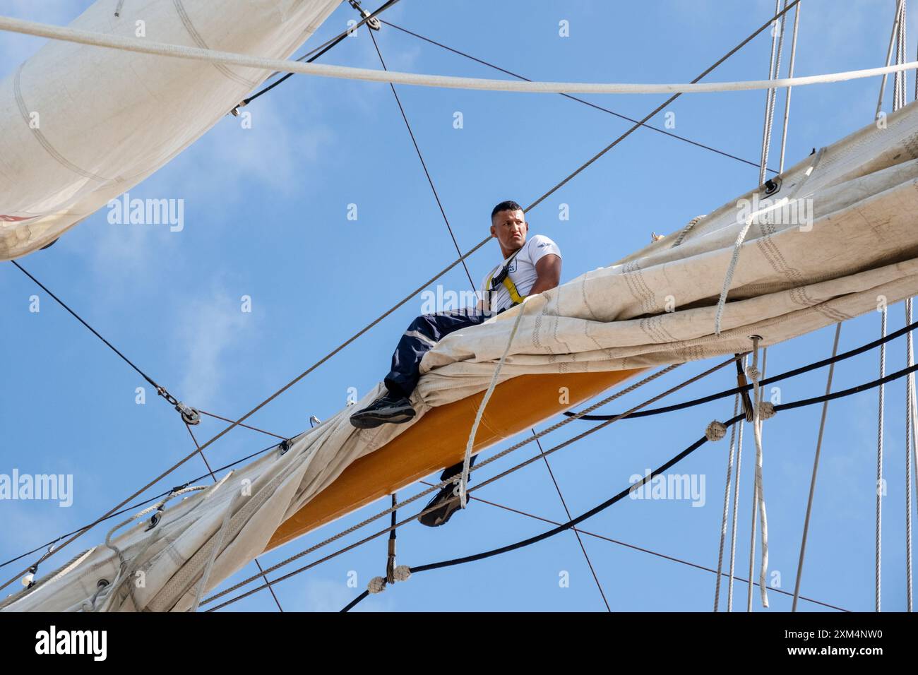 MARIEHAMN, Åland, FINLANDIA - LUGLIO 25 2024: I marinai salgono in alto nel cielo per lavorare sulle vele sugli alberi del sommergibile Guayas dall'Ecuador. Secondo giorno della terza tappa Åland della corsa delle navi alte 2024 nel porto principale, Mariehamn, Åland, Finlandia. Foto: Rob Watkins/Alamy Live News. INFO: La Tall Ships Race è un evento velico annuale che comprende navi d'alto livello storiche e moderne. Promuove l'amicizia internazionale e la formazione dei giovani, attirando partecipanti e spettatori in tutto il mondo per celebrare il patrimonio marittimo e l'arte della vela tradizionale. Foto Stock