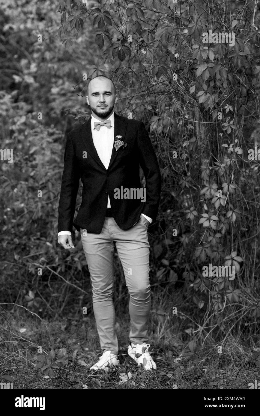 ragazzo balsamico in giacca marrone su fondo di uva rossa selvatica Foto Stock