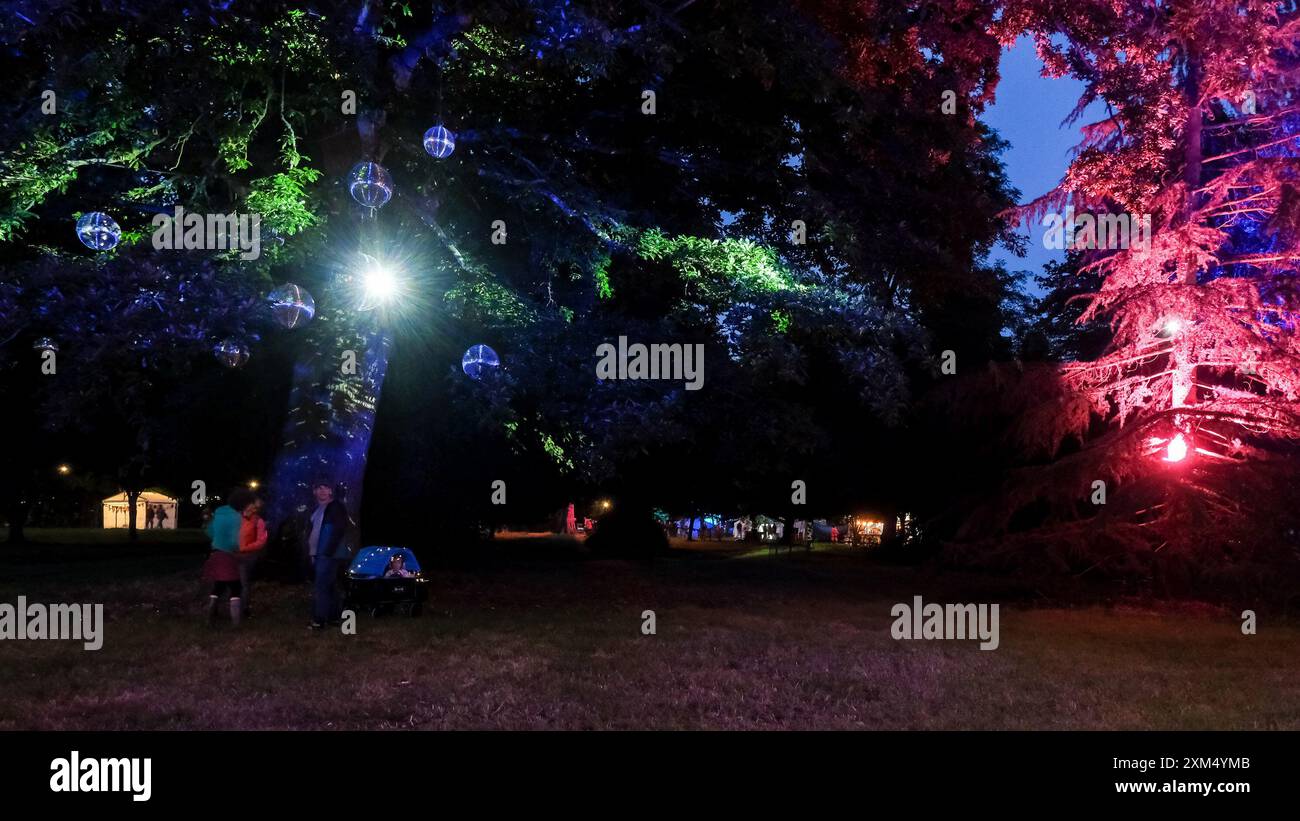 Malmesbury, Regno Unito. 25 luglio 2024. Atmosfera durante Womad - World of Music, Arts and Dance 2024. Gli alberi dell'arboreto sono illuminati in vari colori con palline scintillanti. Foto di Julie Edwards./Alamy Live News Foto Stock