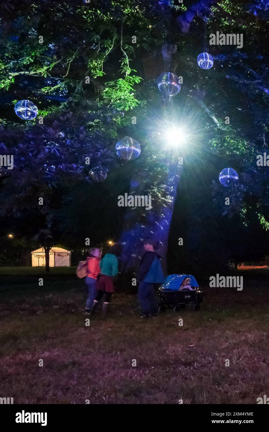 Malmesbury, Regno Unito. 25 luglio 2024. Atmosfera durante Womad - World of Music, Arts and Dance 2024. Gli alberi dell'arboreto sono illuminati in vari colori con palline scintillanti. Foto di Julie Edwards./Alamy Live News Foto Stock