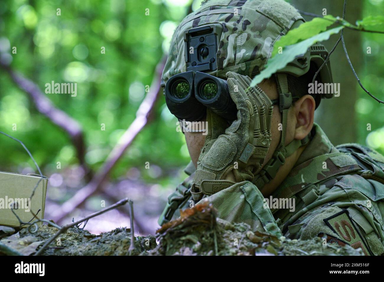 L'Airman Phillip Trinh, un difensore del 315th Security Forces Squadron, Joint base Charleston, South Carolina, utilizza un binocolo durante un'esercitazione di difesa statica presso il Camp James A. Garfield Joint Military Training Center, Ohio, 16 maggio 2024. Trinh si è recata alla Youngstown Air Reserve Station, Ohio, per partecipare al corso di addestramento di 15 giorni del Integrated Defense Leadership Course dell'Air Force Reserve Command per garantire che i membri siano pronti a schierarsi in luoghi di impiego di combattimento agili. (Foto dell'aeronautica militare statunitense di staff Sgt. Christina Russo) Foto Stock