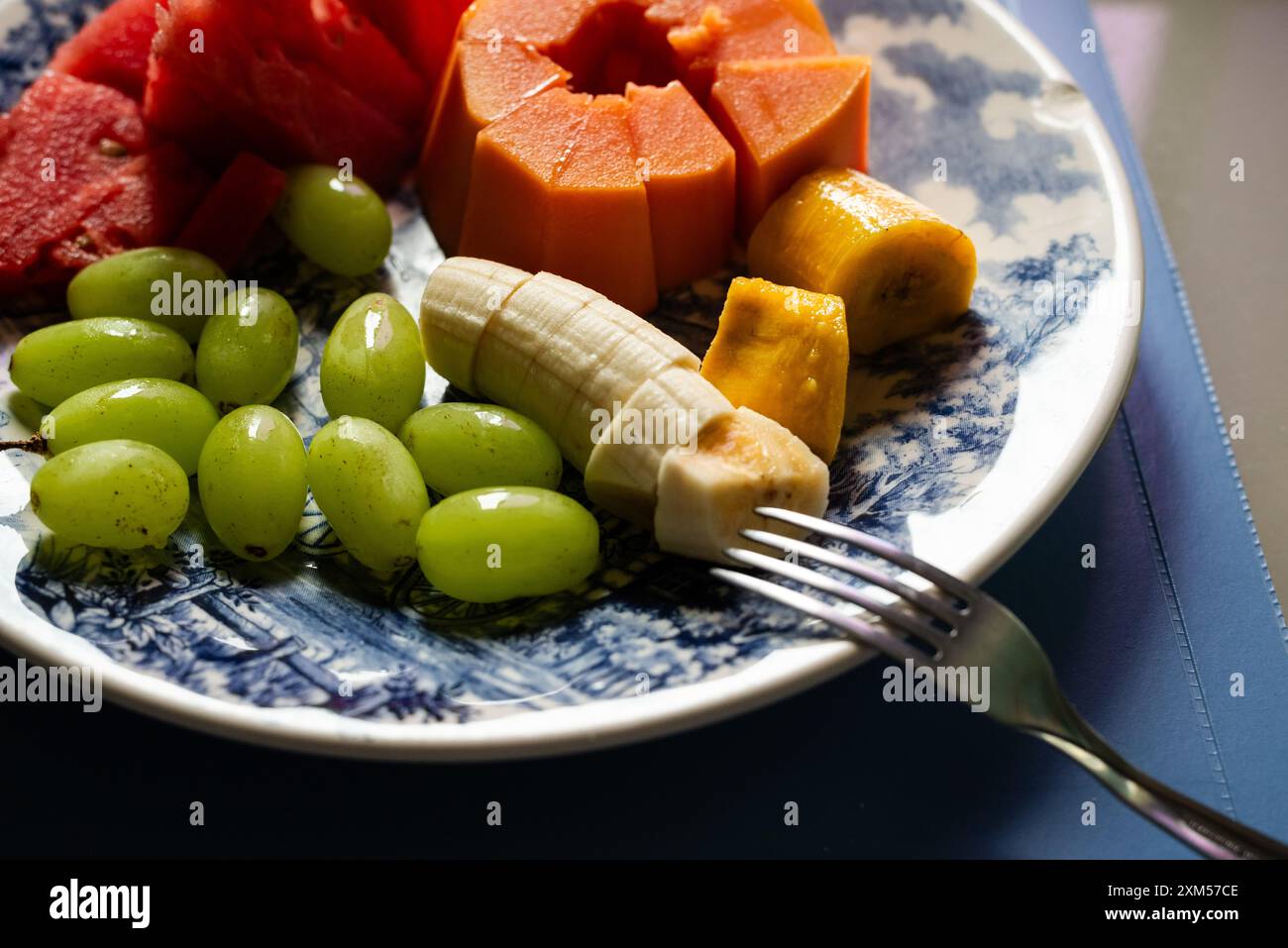 Papaya anguria uva e banane all'interno di un piatto. Colazione. mangiare sano. Frutta. Foto Stock