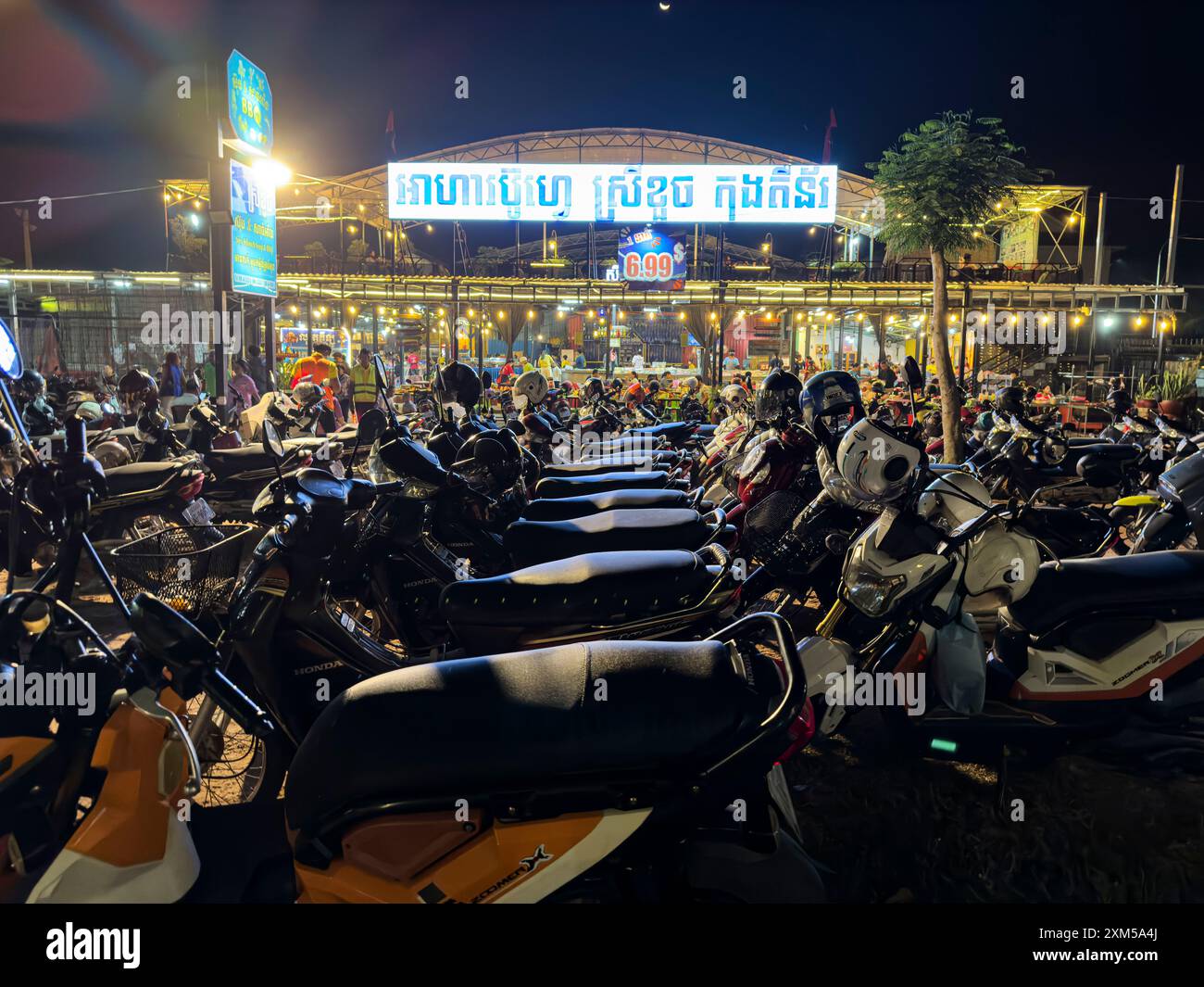 Affari con molti scooter parcheggiati di notte a Siem Reap, in Cambogia. Foto Stock