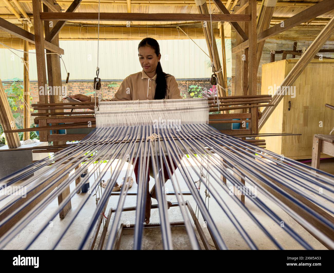 Artigiano che lavora su vari progetti presso il Satcha Handicraft Center di Siem Reap, Cambogia. Foto Stock