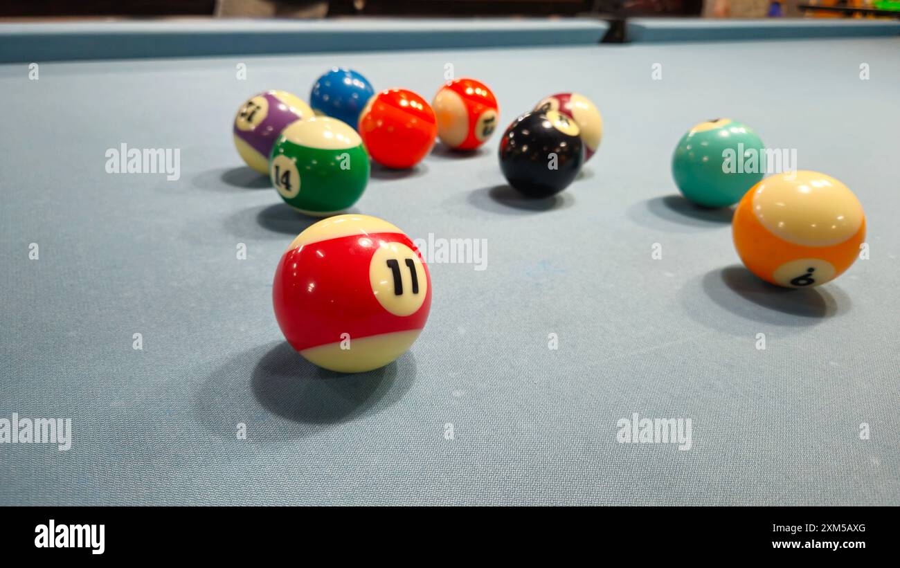 Primo piano di palline da biliardo su un set di giochi da tavolo grigio noto come piscina da otto palloni, sei tasche, sport di punta. Foto Stock