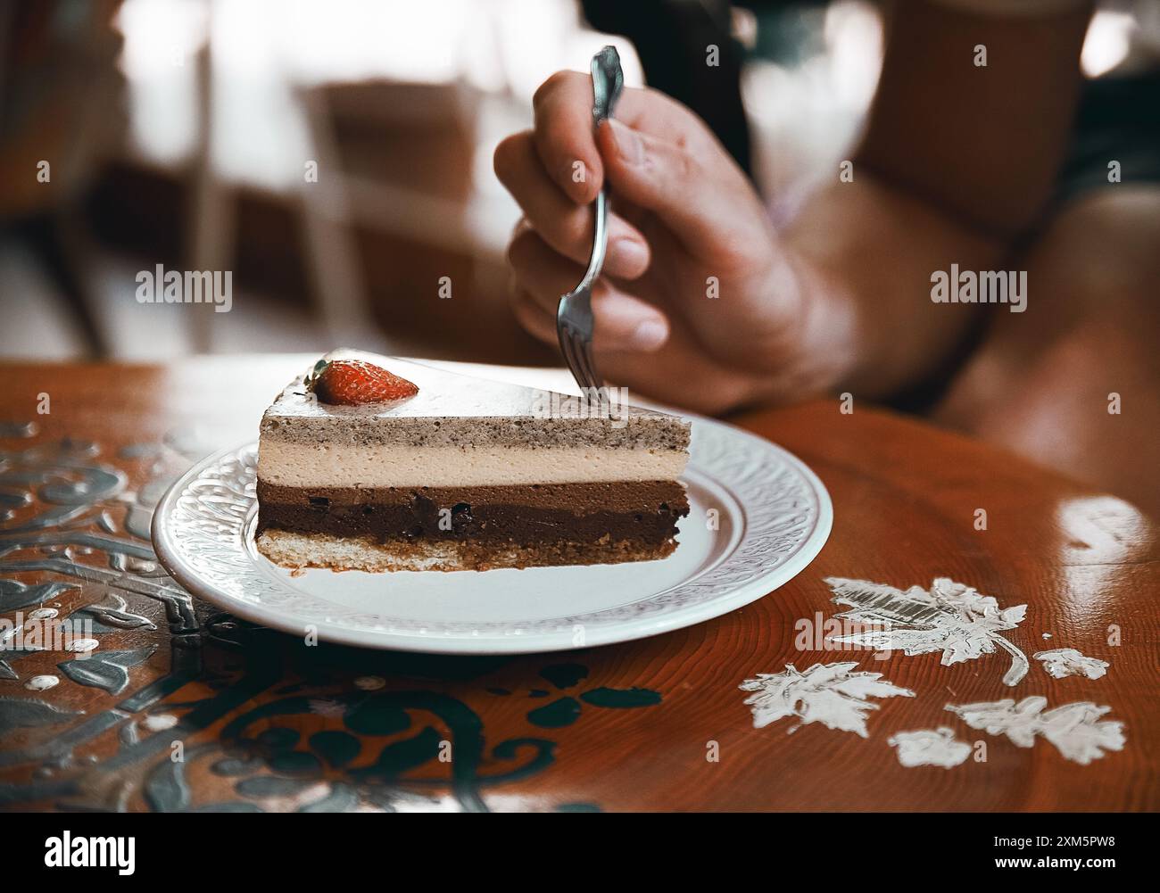 Alanya, Turchia, 17 settembre 2020: Torta al cioccolato alla fragola con cappuccino su un tavolo di legno in una caffetteria Foto Stock