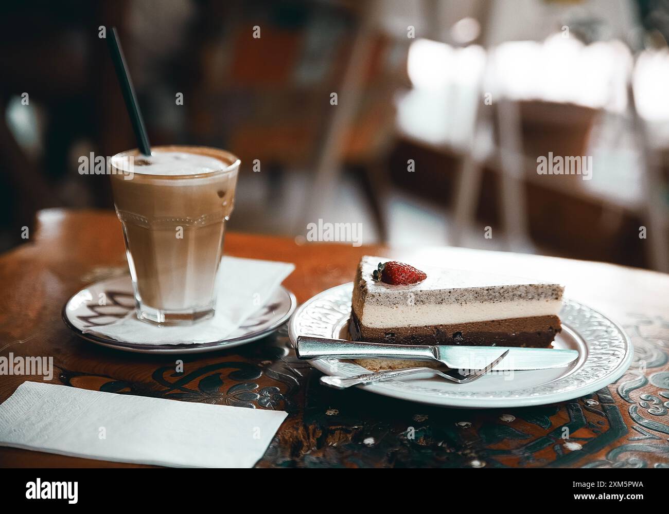 Alanya, Turchia, 17 settembre 2020: Torta al cioccolato alla fragola con cappuccino su un tavolo di legno in una caffetteria Foto Stock
