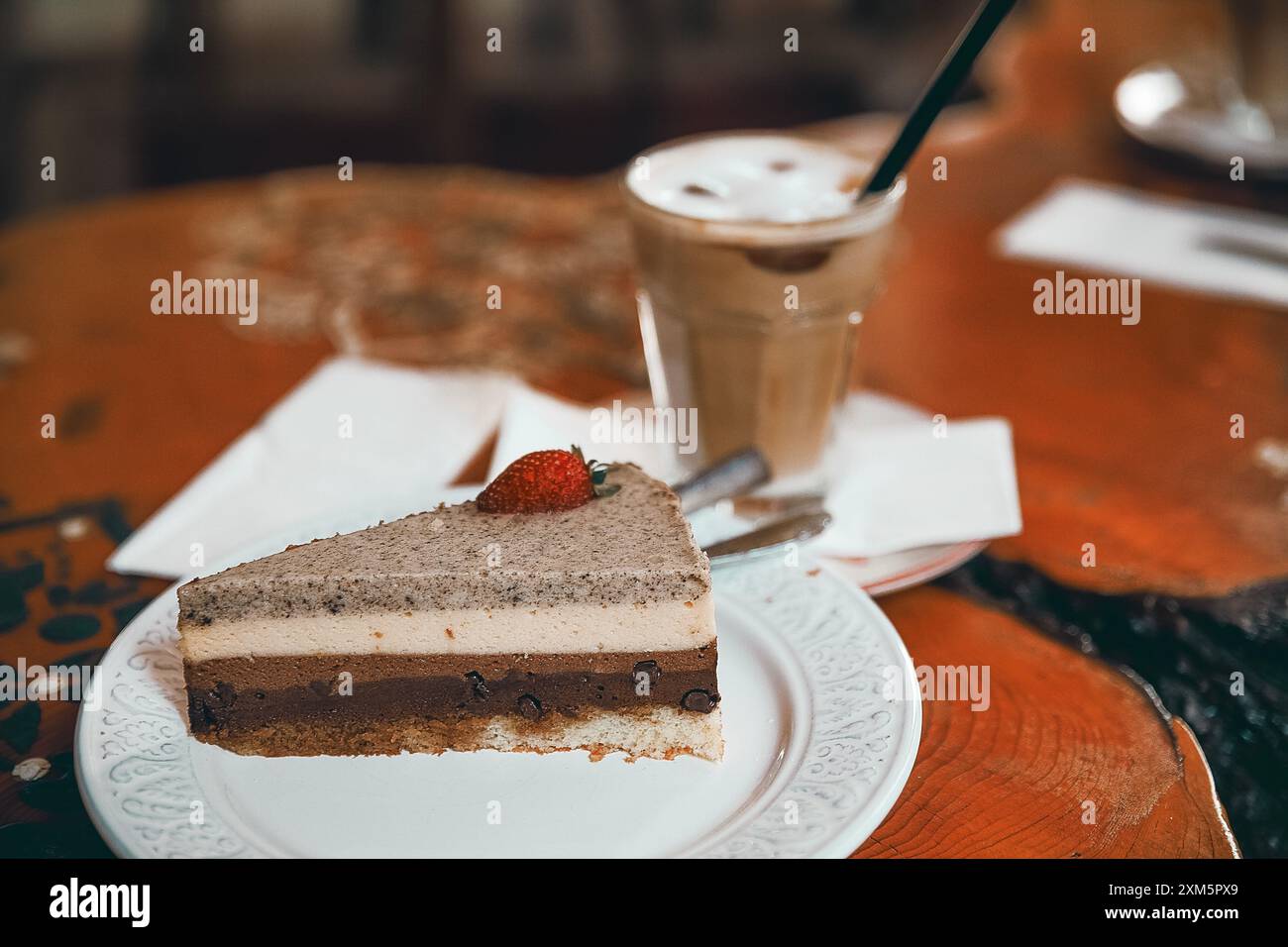 Alanya, Turchia, 17 settembre 2020: Torta al cioccolato alla fragola con cappuccino su un tavolo di legno in una caffetteria Foto Stock