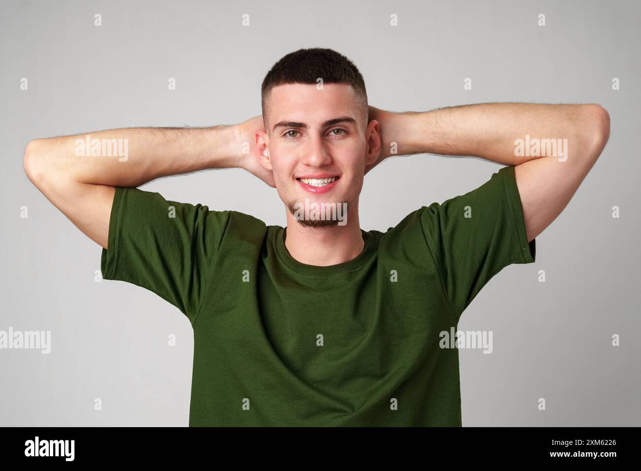 Uomo che indossa pantaloncini verdi e T-shirt in posa in Studio Foto Stock