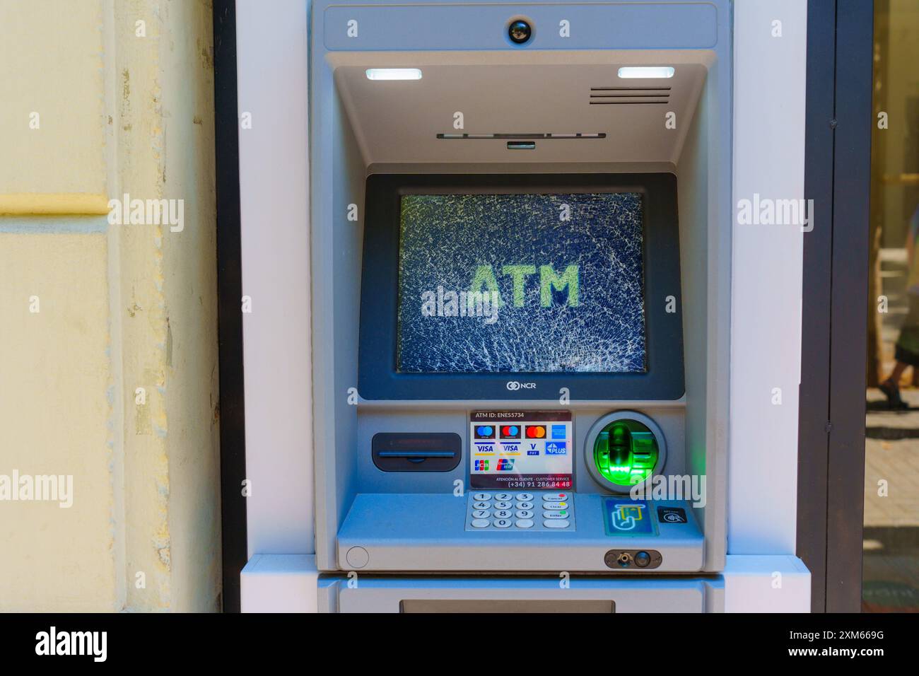 Barcellona, Spagna - 16 luglio 2024: Bancomat con schermo incrinato che visualizza il messaggio "bancomat". Foto Stock