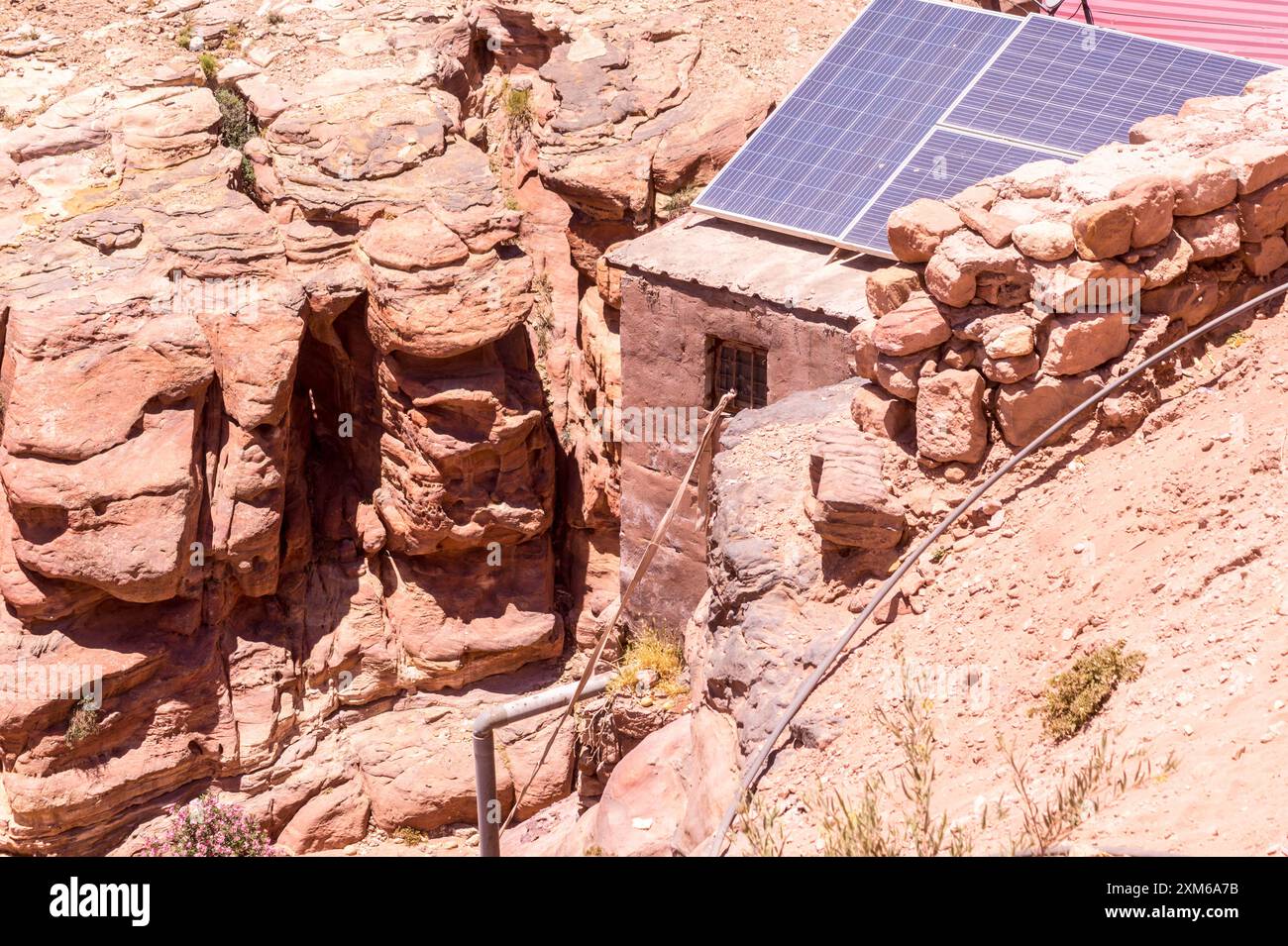 Pannelli fotovoltaici solari sul tetto di una tradizionale casa beduina, sito patrimonio dell'umanità dell'UNESCO di Petra, Giordania Foto Stock