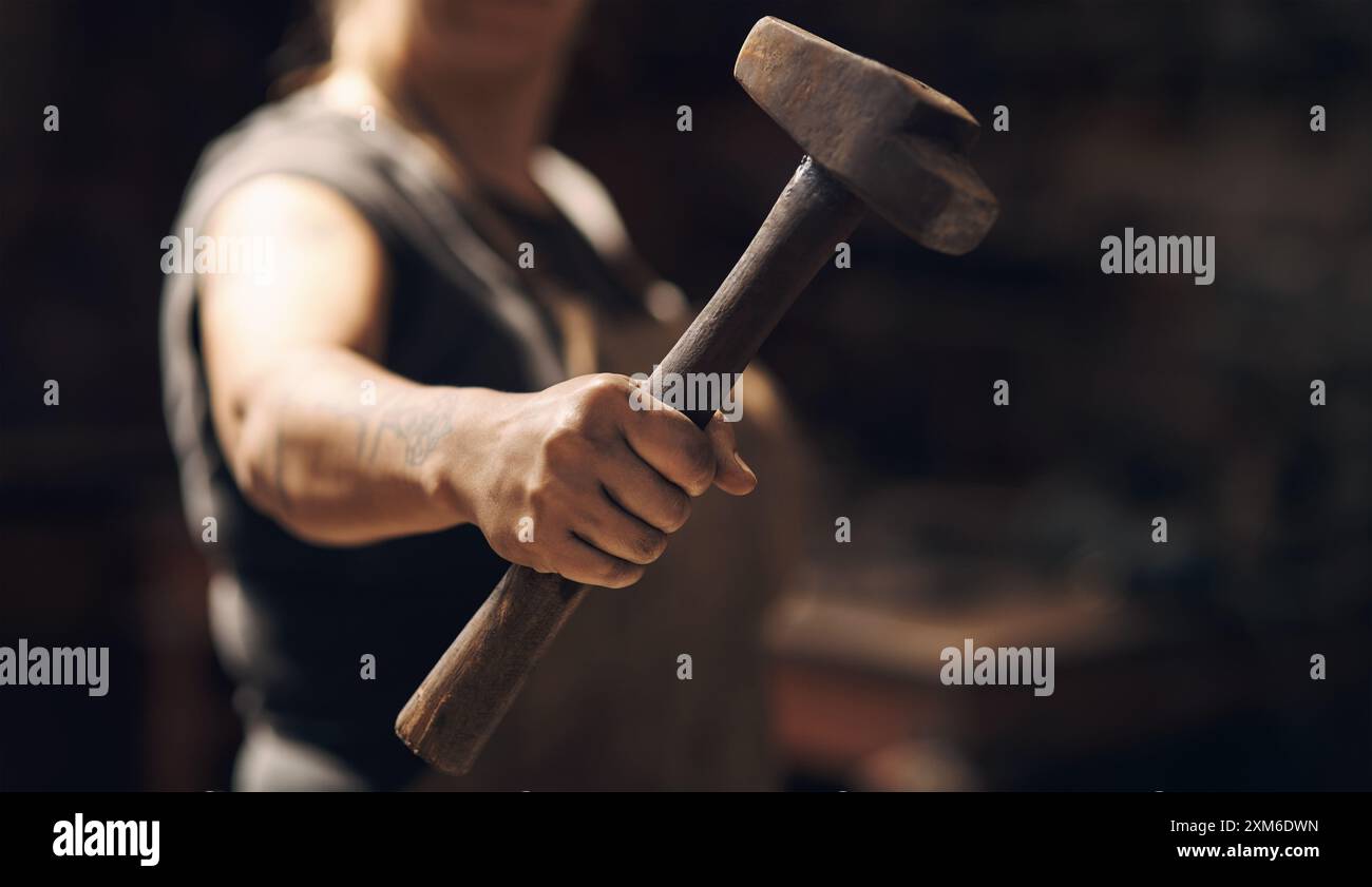 Donna, mano e mano martello con piccola impresa per la lavorazione di metallo e oggetti in officina. Donna, fabbro e empowerment o affermativo Foto Stock